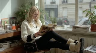 May be an image of one or more people, people studying, chaise lounge, boots, turtleneck, cardigan and text